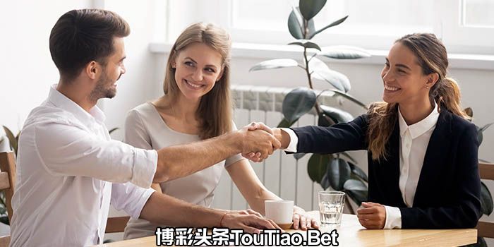 A businessman shakes hands with two businesswomen
